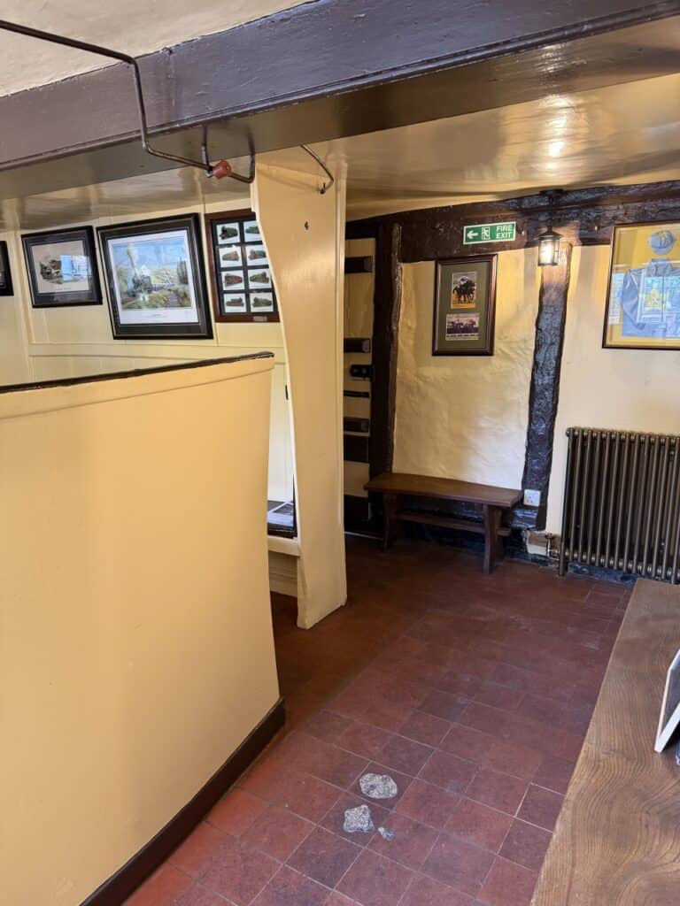 Pub corridor with exposed beams and a tiled floor
